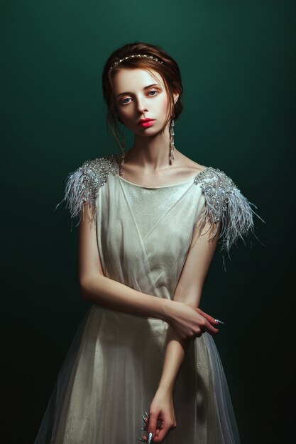 Chica en un elegante vestido posando en un estudio.