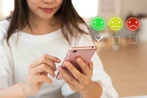 Foto chica eligiendo el icono de la cara de sonrisa feliz verde para dar satisfacción en el servicio el cliente puede evaluar la calidad del servicio que conduce a la clasificación de reputación del negocio servicio al cliente y concepto de satisfacción