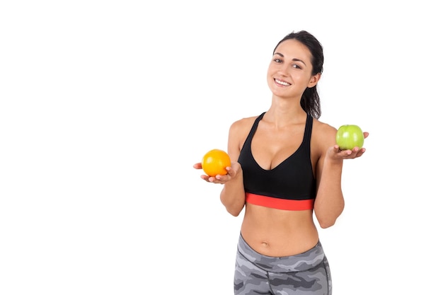 Chica eligiendo entre una manzana y una naranja