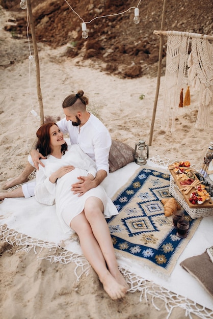 Chica embarazada y novio en un picnic