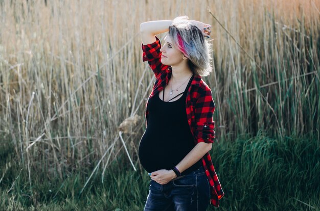 Chica embarazada en ropa casual de moda. Maternidad feliz y saludable