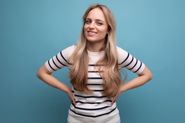 Chica encantadora en ropa casual posando sobre un fondo azul aislado