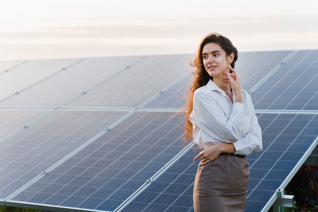 Chica se encuentra cerca de las filas de paneles solares en el suelo