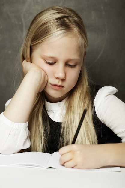 Chica escribiendo en el aula - prueba o examen