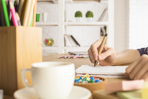 Chica escribiendo en el bloc de notas