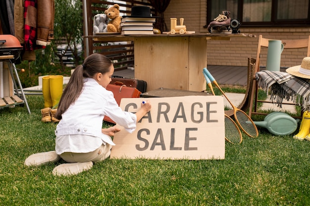 Chica escribiendo venta de garaje en banner