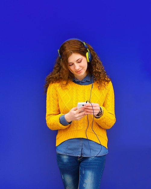 Chica escuchando música en auriculares con smartphone