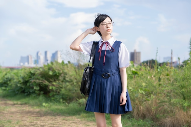 Chica de la escuela secundaria asiática con pelo negro corto con gafas