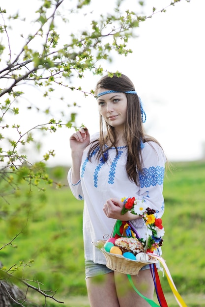 Chica eslava en camisa ucraniana en la naturaleza