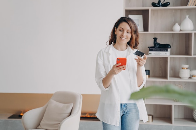 Chica española feliz tiene tarjeta de crédito y teléfono Compras en línea ahorro de dinero y descuento