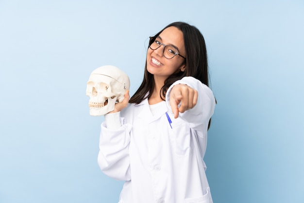 Foto la chica especialista forense de la policía sobre una pared aislada te señala con una expresión segura