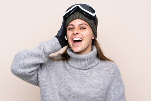 Chica esquiador adolescente con gafas de snowboard con sorpresa y expresión facial conmocionada