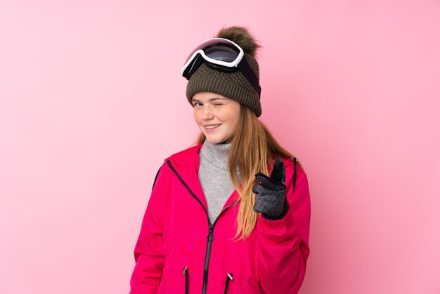 Chica esquiador adolescente ucraniano con gafas de snowboard sobre puntos de puntos rosados aislados en usted