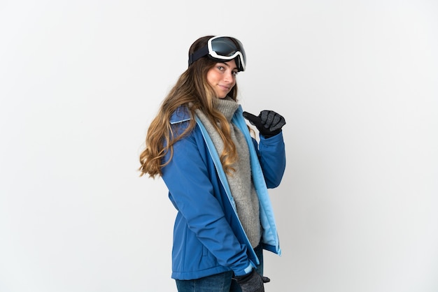 Chica esquiador con gafas de snowboard aislado en la pared blanca orgulloso y satisfecho de sí mismo