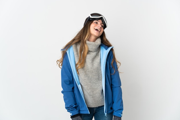 Chica esquiador con gafas de snowboard aislado en la pared blanca riendo