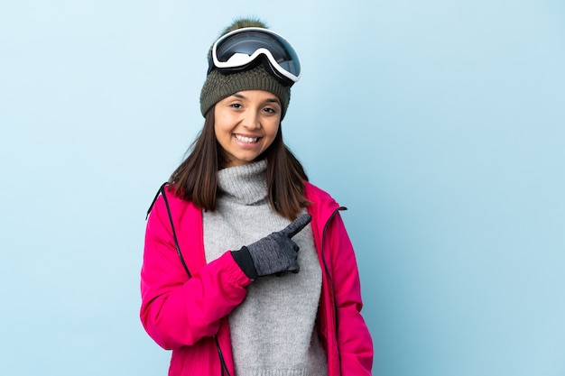 Chica de esquiador de raza mixta con gafas de snowboard aislado