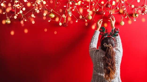 Chica está decorando con adornos navideños