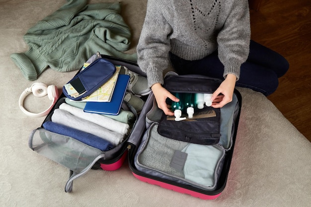La chica está empacando una maleta para el viaje empacando su equipaje