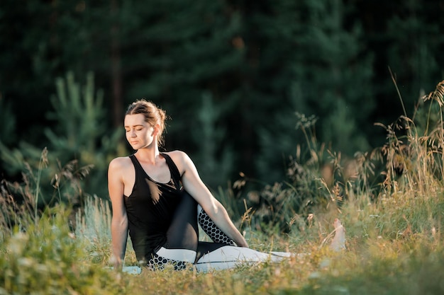 La chica está haciendo yoga al aire libre El concepto de deporte