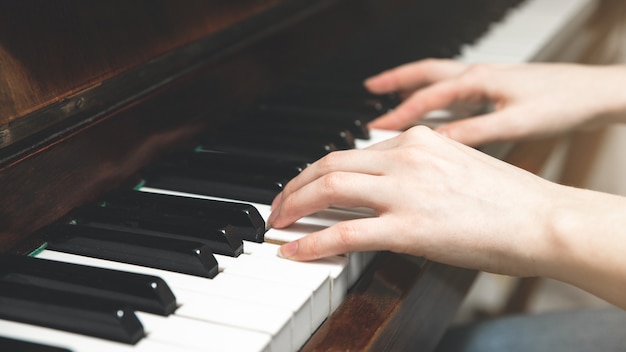 Chica está tocando el piano. Creación de música. Hobby sobre el tiempo de cuarentena. Aprender cosas nuevas.