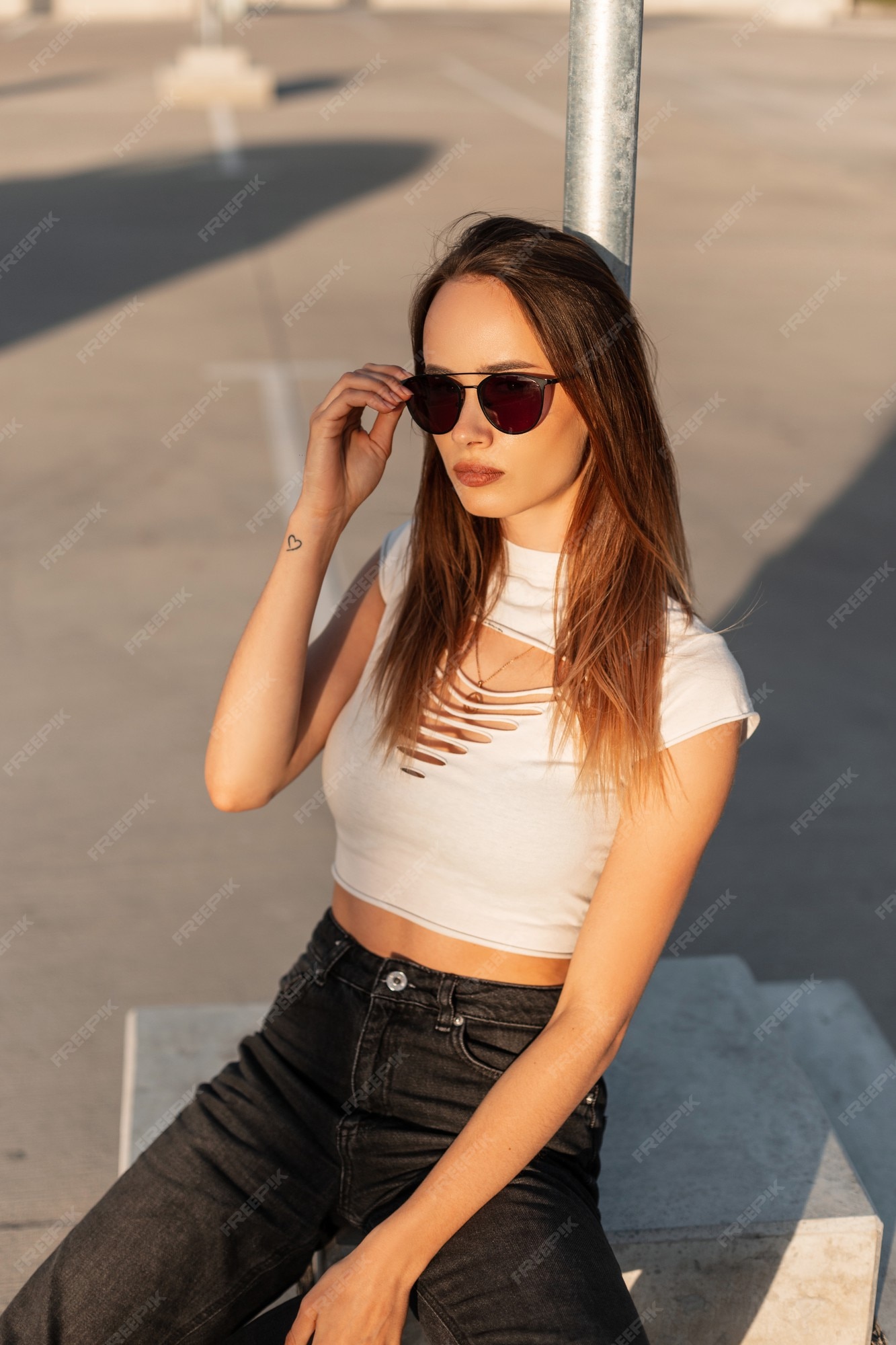 Chica con estilo joven inconformista en gorra de béisbol endereza gafas de  sol de moda en un día soleado. modelo de hermosa mujer urbana en ropa de moda  juvenil posando en el