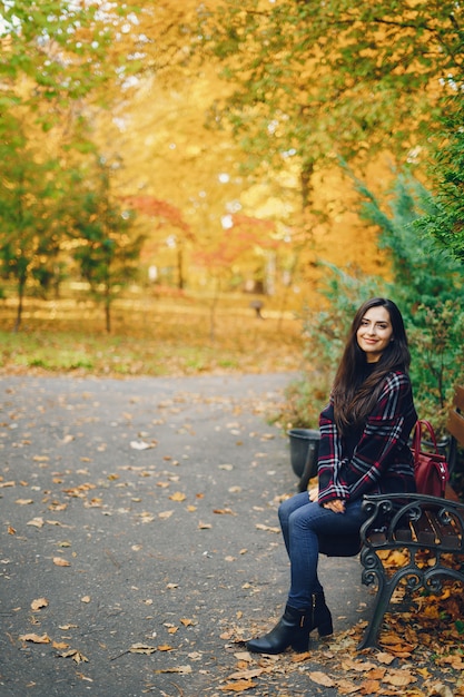 chica con estilo que explora la ciudad y el parque en el otoño