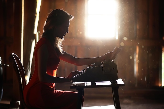 Una chica de estilo retro imprime en una vieja máquina de escribir