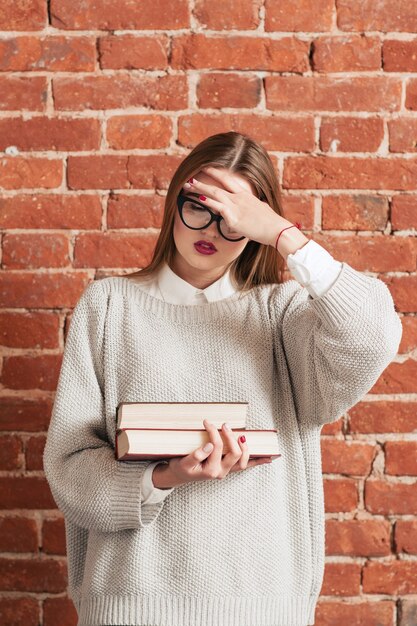 Chica estresada con libros olvidó algo importante