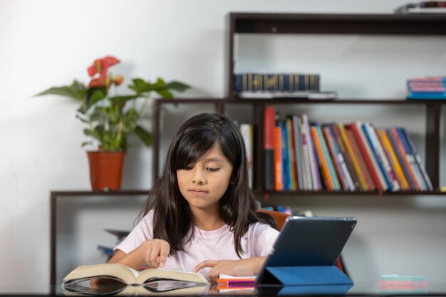 Chica estudiando en línea con tableta en casa