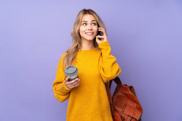 Chica estudiante adolescente aislada sosteniendo café para llevar y un móvil