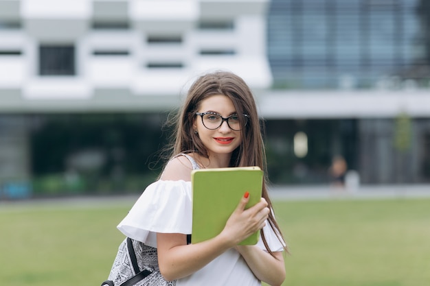 Chica estudiante adolescente posando con tableta digital en el parque al aire libre