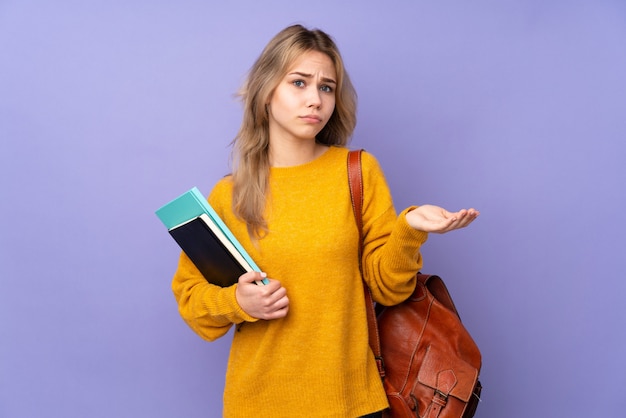 Chica estudiante adolescente en púrpura infeliz por no entender algo