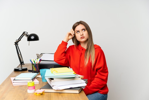 Chica estudiante adolescente en su habitación con dudas y con expresión de rostro confuso