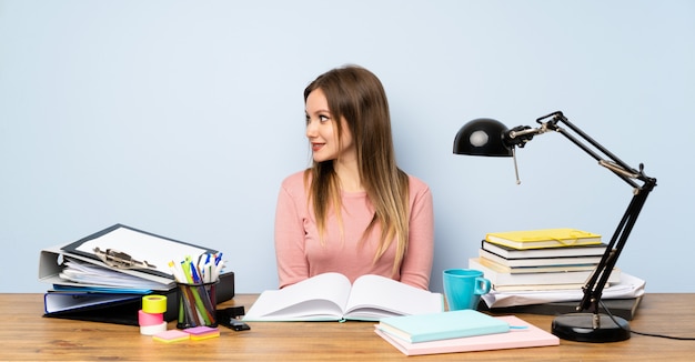 Chica estudiante adolescente en su habitación mirando hacia el lado