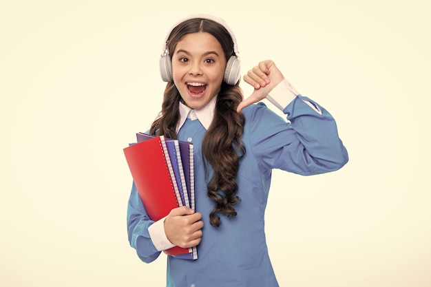 Chica estudiante en auriculares sosteniendo libros Educación en la escuela o la universidad