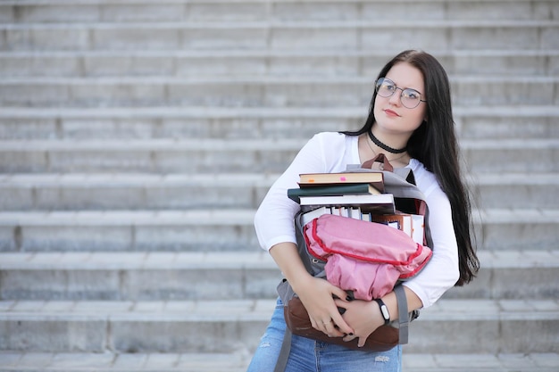 Foto chica estudiante en la calle con libros