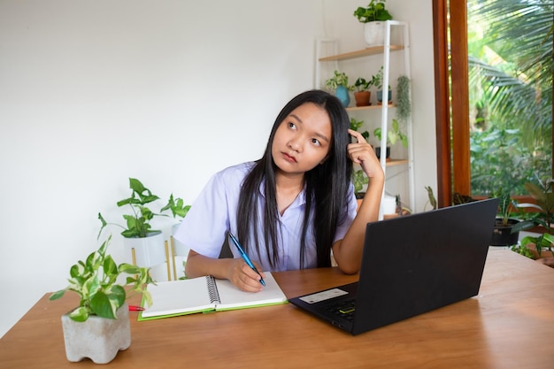 Chica estudiante estudio por slfe en la computadora portátil en la habitación