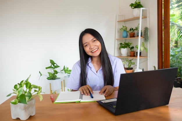 Chica estudiante estudio por slfe en la computadora portátil en la habitación