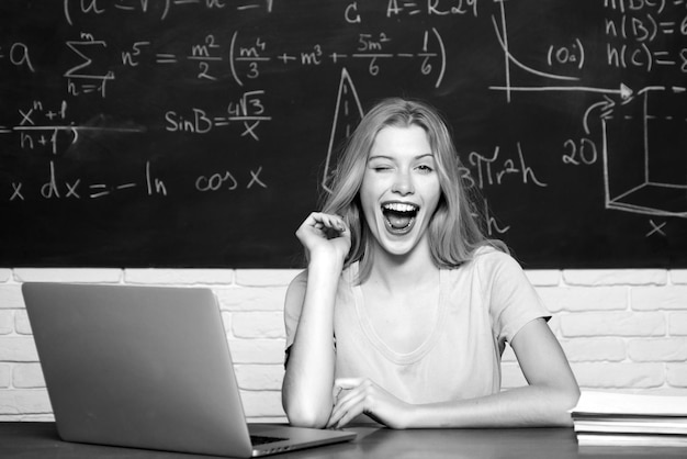 Chica estudiante con expresión de cara feliz cerca del escritorio con útiles escolares estudiantes adolescentes con escuela