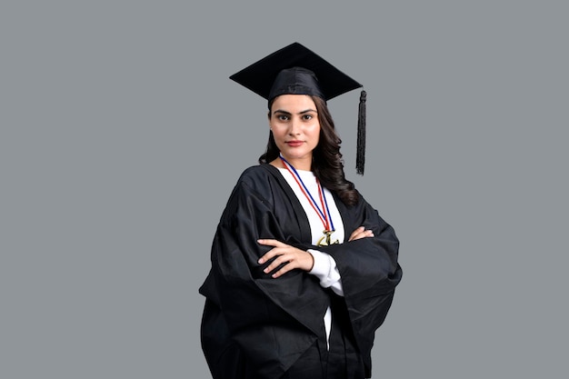 Chica estudiante graduada aislada sobre fondo gris modelo paquistaní indio