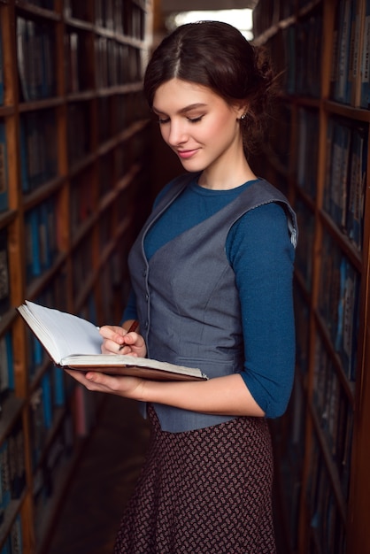 Chica estudiante hace notas en el cuaderno.