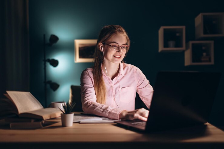 Chica estudiante de jengibre entusiasta usando una computadora portátil