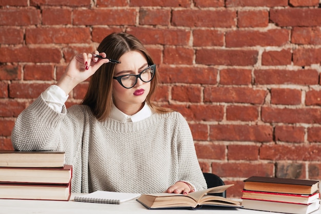 Chica estudiante leyendo atentamente el libro