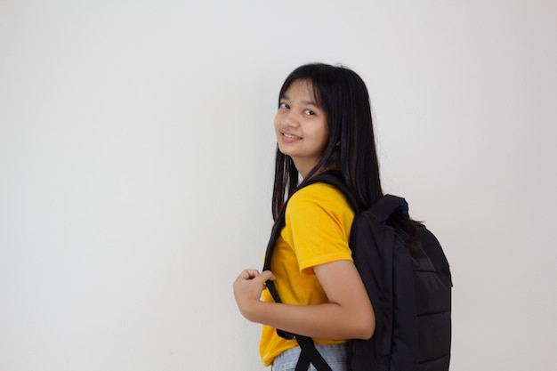 Chica estudiante con mochila smilling sobre fondo blanco.