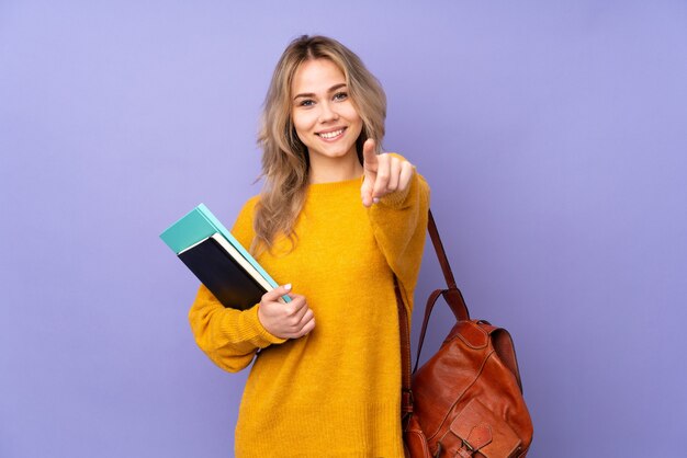 Chica estudiante rusa haciendo gesto de teléfono y apuntando hacia el frente