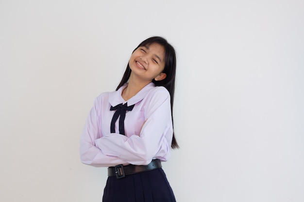 Chica estudiante en uniforme sobre fondo blanco.