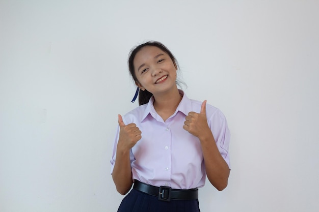 Chica estudiante en uniforme sobre fondo blanco.