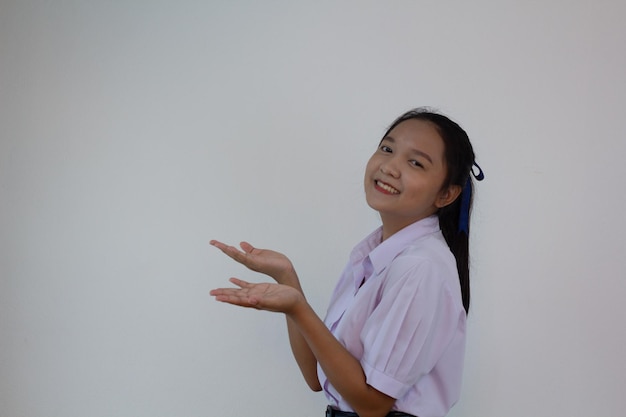 Chica estudiante en uniforme sobre fondo blanco.