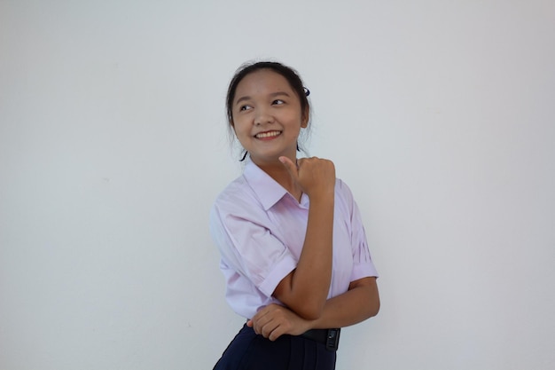 Chica estudiante en uniforme sobre fondo blanco.