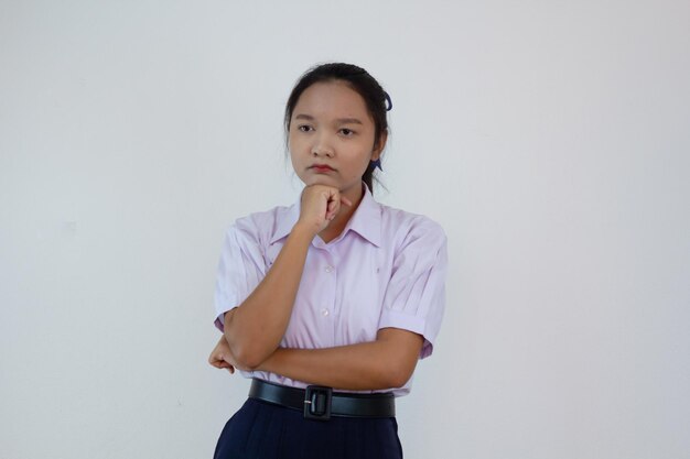 Chica estudiante en uniforme sobre fondo blanco.